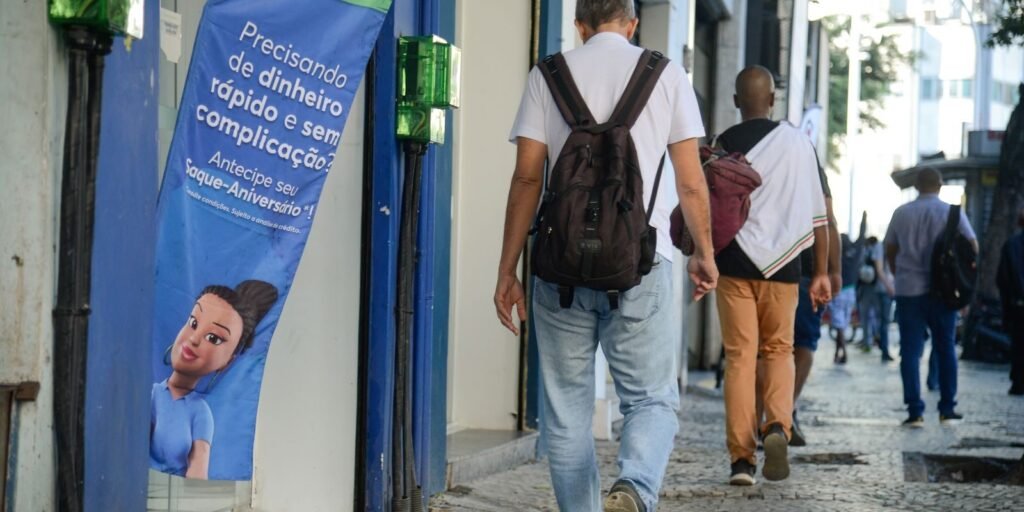 Bandeira com propaganda oferece empréstimo em rua movimentada do centro do Rio de Janeiro