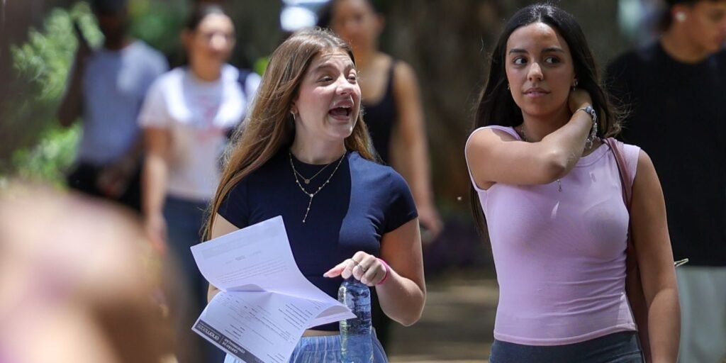 Candidatas com papéis na mão chegando a local de prova