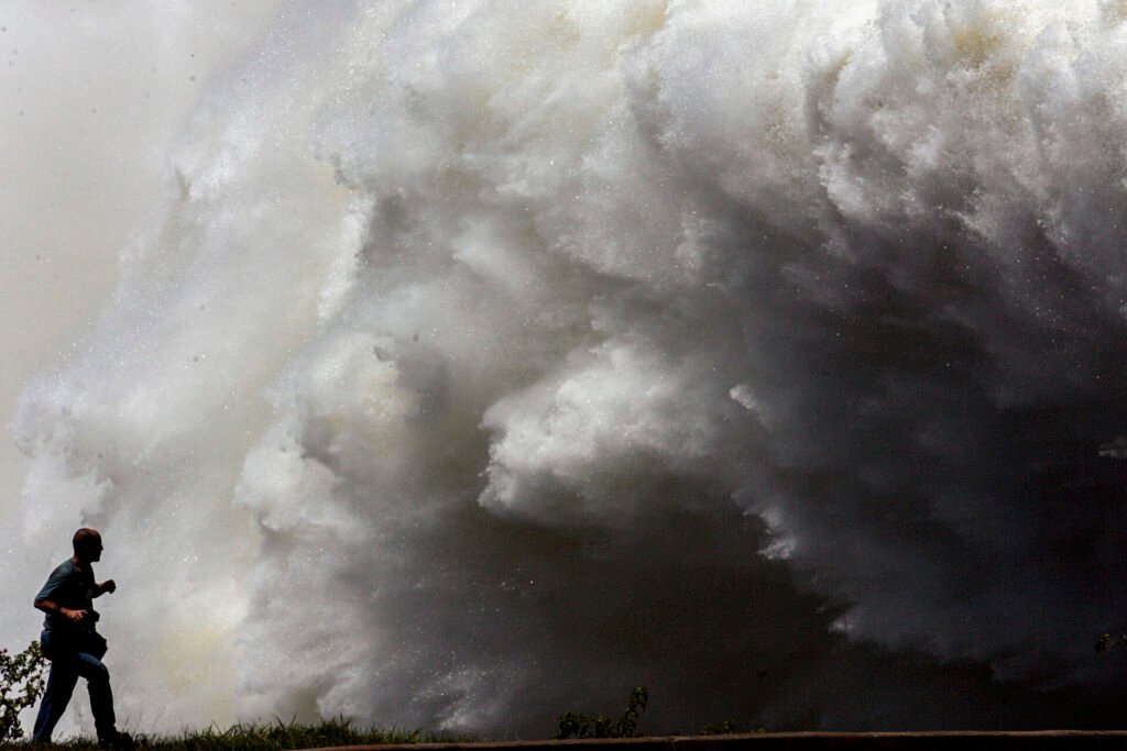 Explosão de água em uma das comportas da hidrelétrica de Itaipu Binacional, no trecho de fronteira entre Brasil e Paraguai