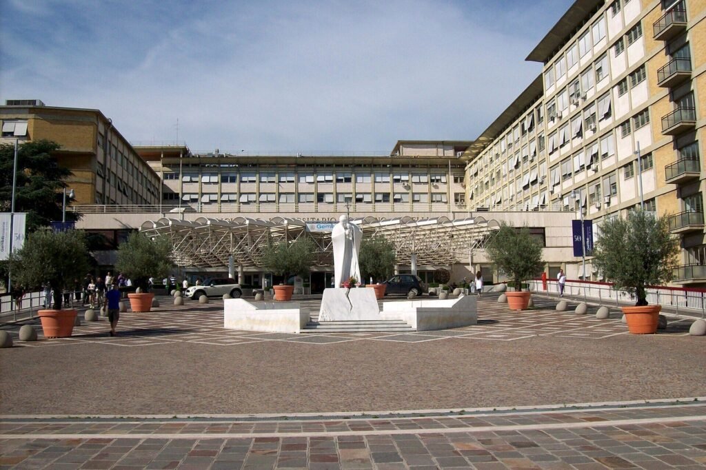 Praça de entrada do hospital Gemelli com a estátua de João Paulo 2º