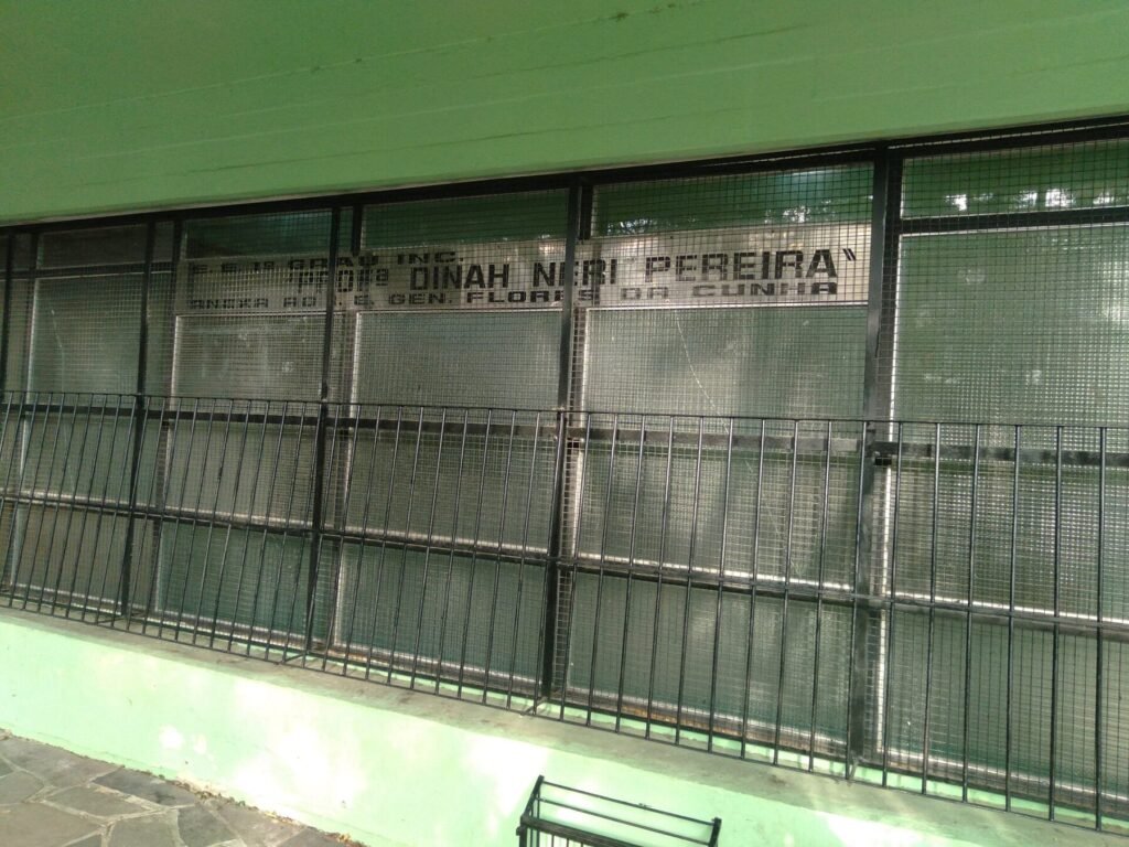 Grade e letreiro na entrada da Escola Estadual Professora Dinah Néri Pereira