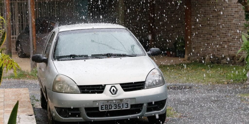 Granizo caindo sobre carro estacionado