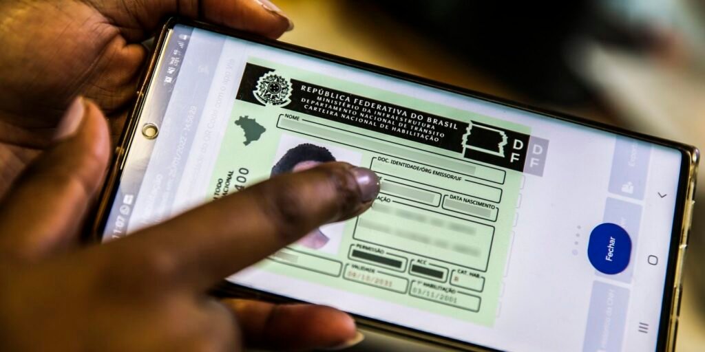 Mão segurando celular com documento de trânsito digital na tela