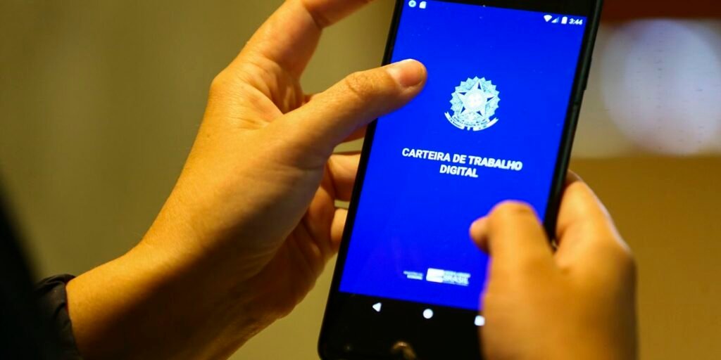 Mãos segurando celular com o aplicativo da Carteira de Trabalho Digital
