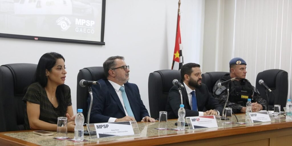 Mesa de entrevista com o painel do MPSP e do Gaeco ao fundo