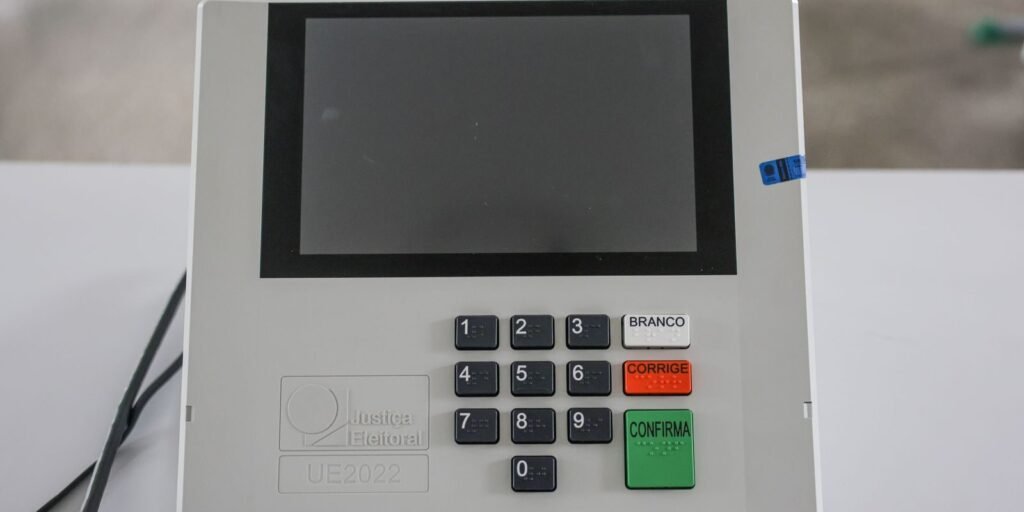Mesário monta urna eletrônica em uma escola pública em Brasília, na véspera do primeiro turno das eleições
