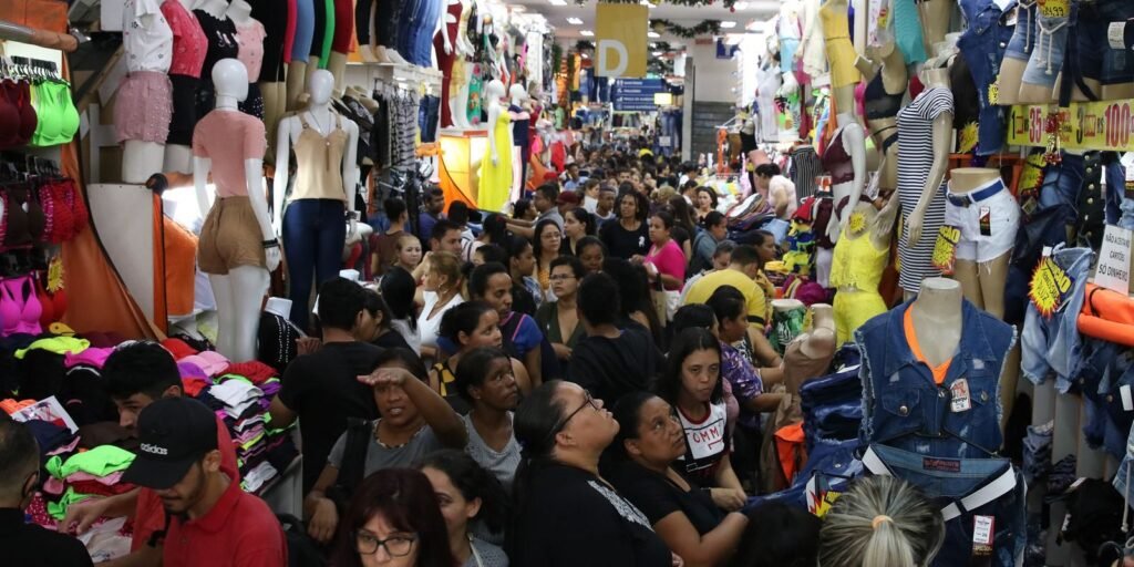Multidão entre lojas de roupas no Brás