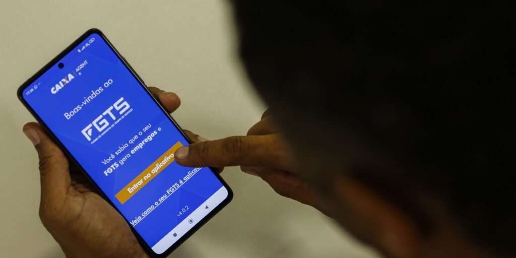 Pessoa toca na tela do aplicativo FGTS em um celular