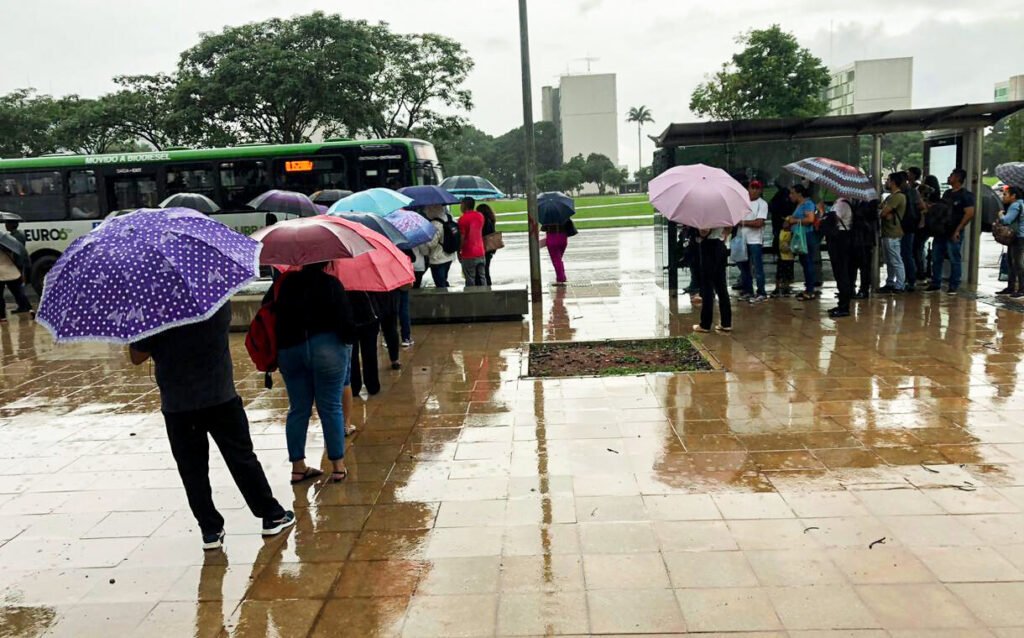 Pessoas com guarda-chuvas durante chuva na Esplanada dos Ministérios, em Brasília
