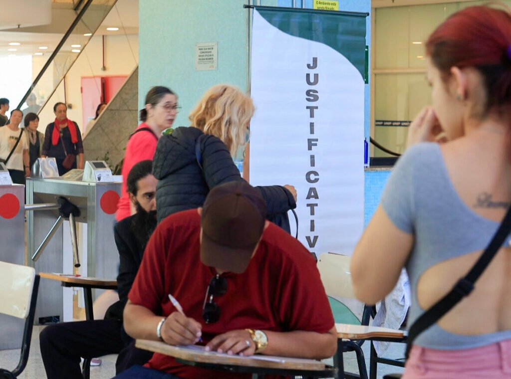 Pessoas justificam o voto no início das eleições, em São Paulo