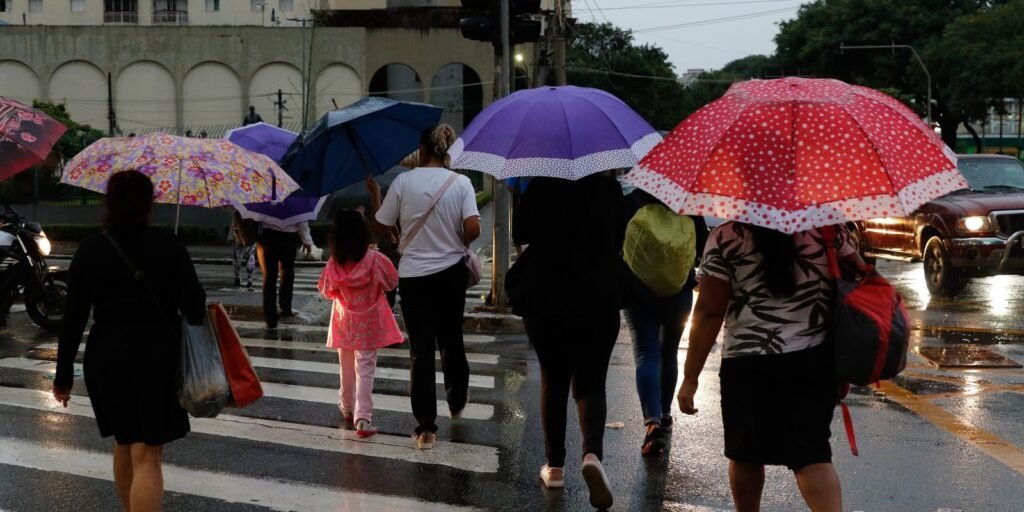 Pessoas se protegem da chuva que deixa São Paulo em estado de atenção no final da tarde, na Avenida Pompéia