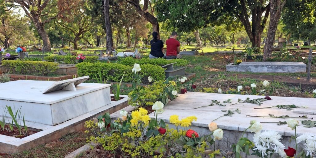 Pessoas visitam túmulos no cemitério Campo da Esperança, em Brasília, durante o Dia de Finados