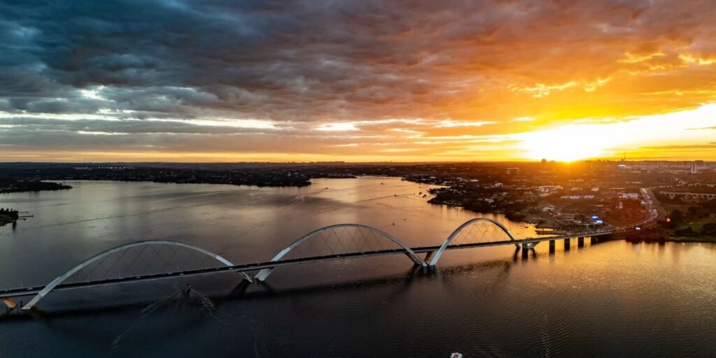 Pôr do sol sobre a Ponte JK e o Lago Paranoá, em Brasília, com composição de céu e água ao fim da tarde