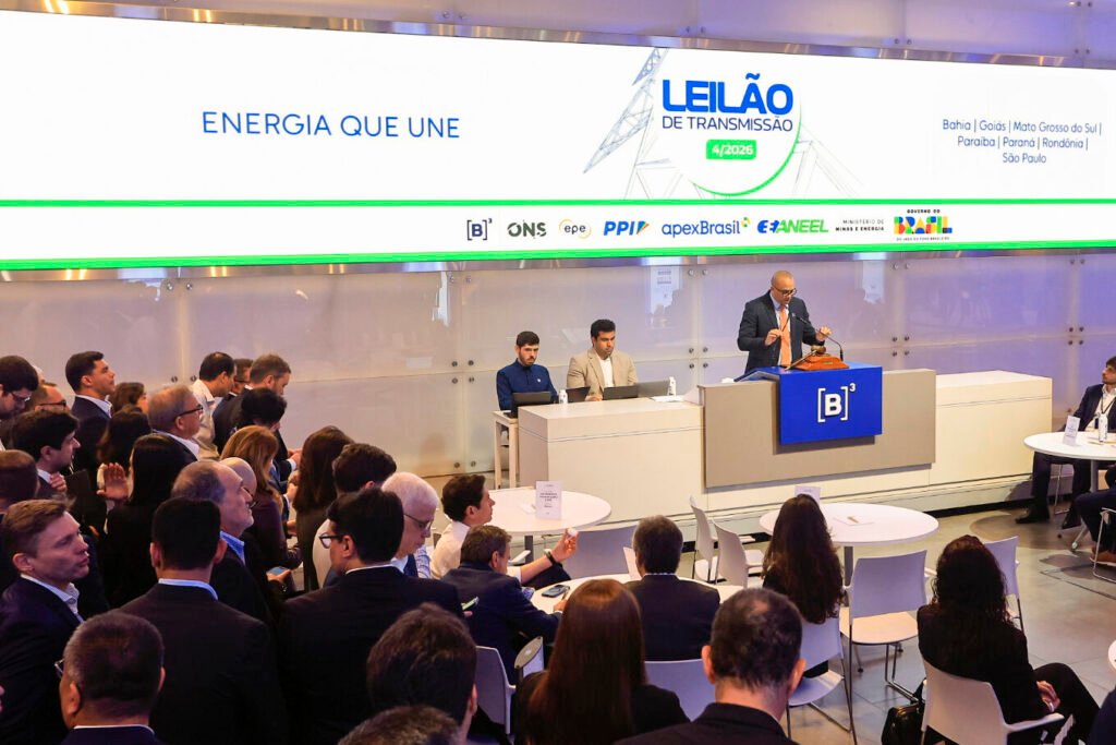 Público no salão da B3 com telão ao fundo