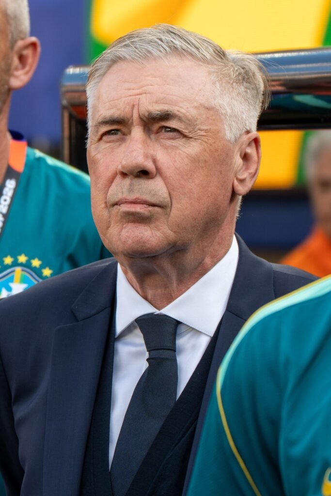 Técnico Carlo Ancelotti, de terno escuro, à beira do campo